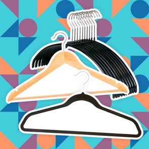 Hangers displayed against a colorful geometric background, with a mix of wooden, plastic, and black velvet hangers overlapping in the foreground.