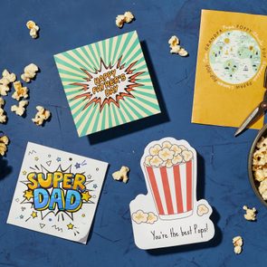 Popcorn spilled from striped box, greeting cards saying 