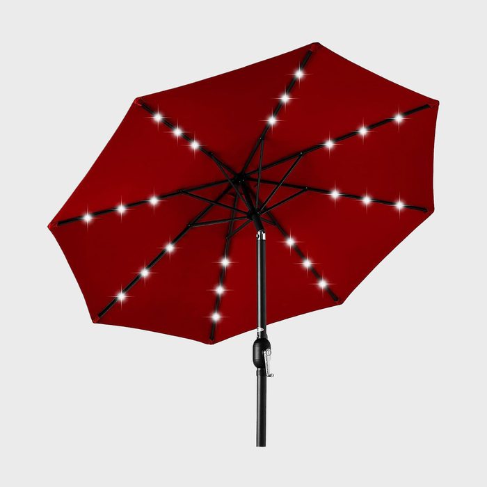 Umbrella displays lights along ribs, creating a starry effect against a plain background.