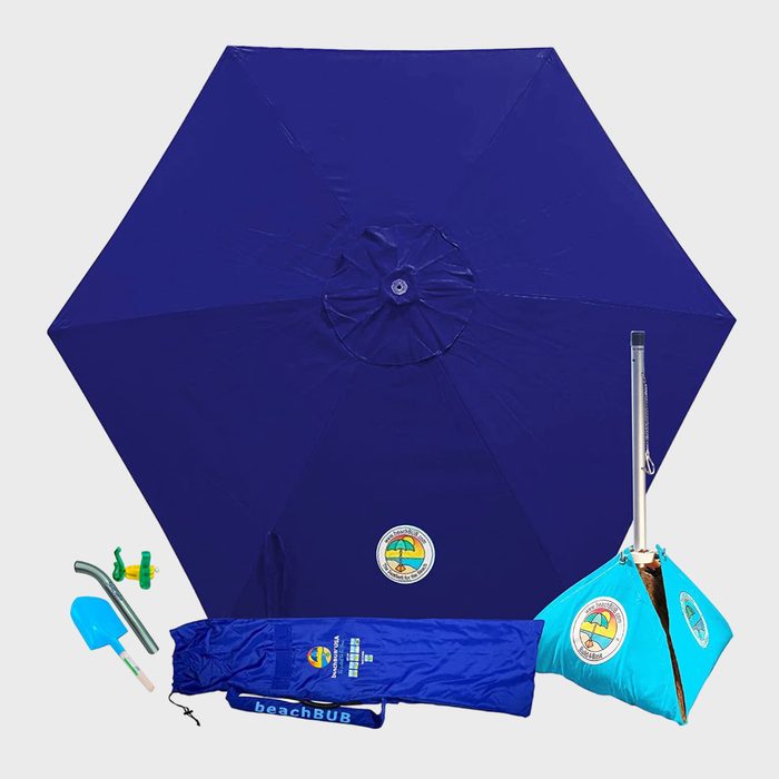 Blue beach umbrella kit includes sand anchor, carrying bag, shovel, and accessories; set against a plain background.