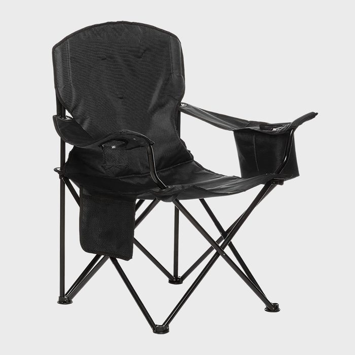 A black folding chair sits open, featuring armrests with a cup holder, placed against a plain, light background.