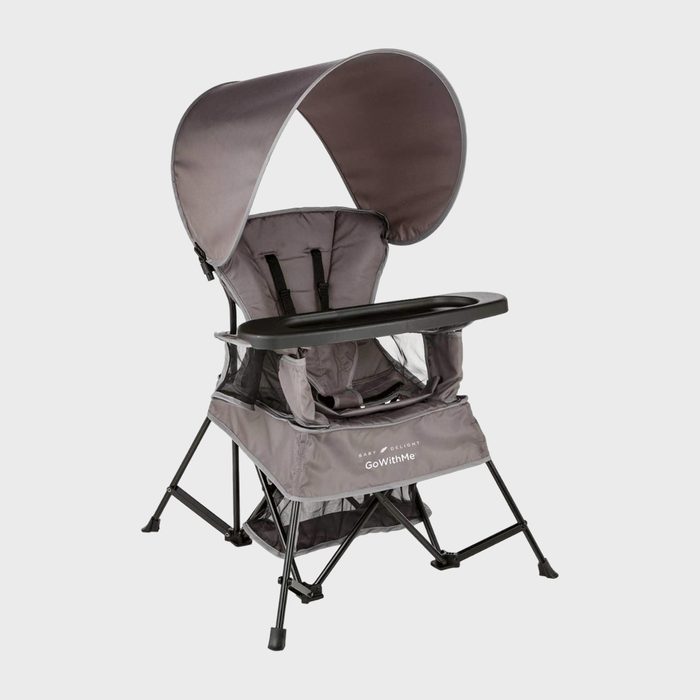 A gray portable high chair with canopy, tray, and safety harness sits on black legs. Text reads: 