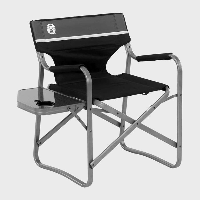 Chair with armrest and side table stands; features a cupholder and black fabric seat in a minimalist indoor setting.