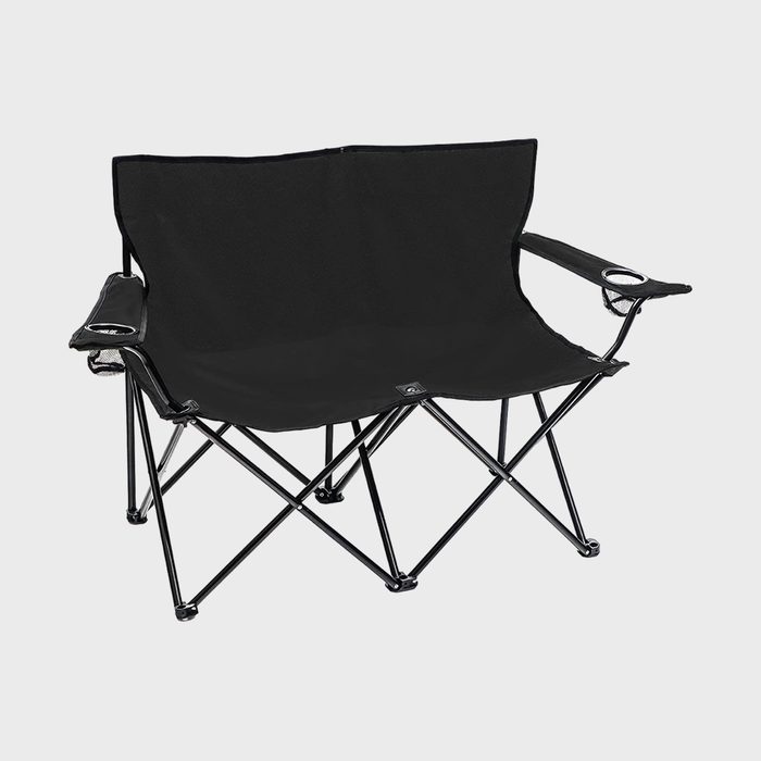 Black folding camping chair sits on a white background, featuring metal legs and armrests with built-in cup holders.