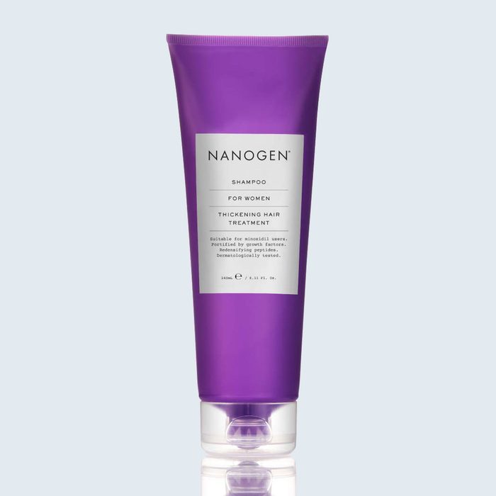 Purple shampoo bottle stands upright, featuring a label stating 