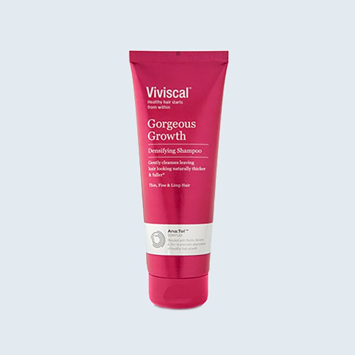 Red shampoo tube stands upright; text reads 
