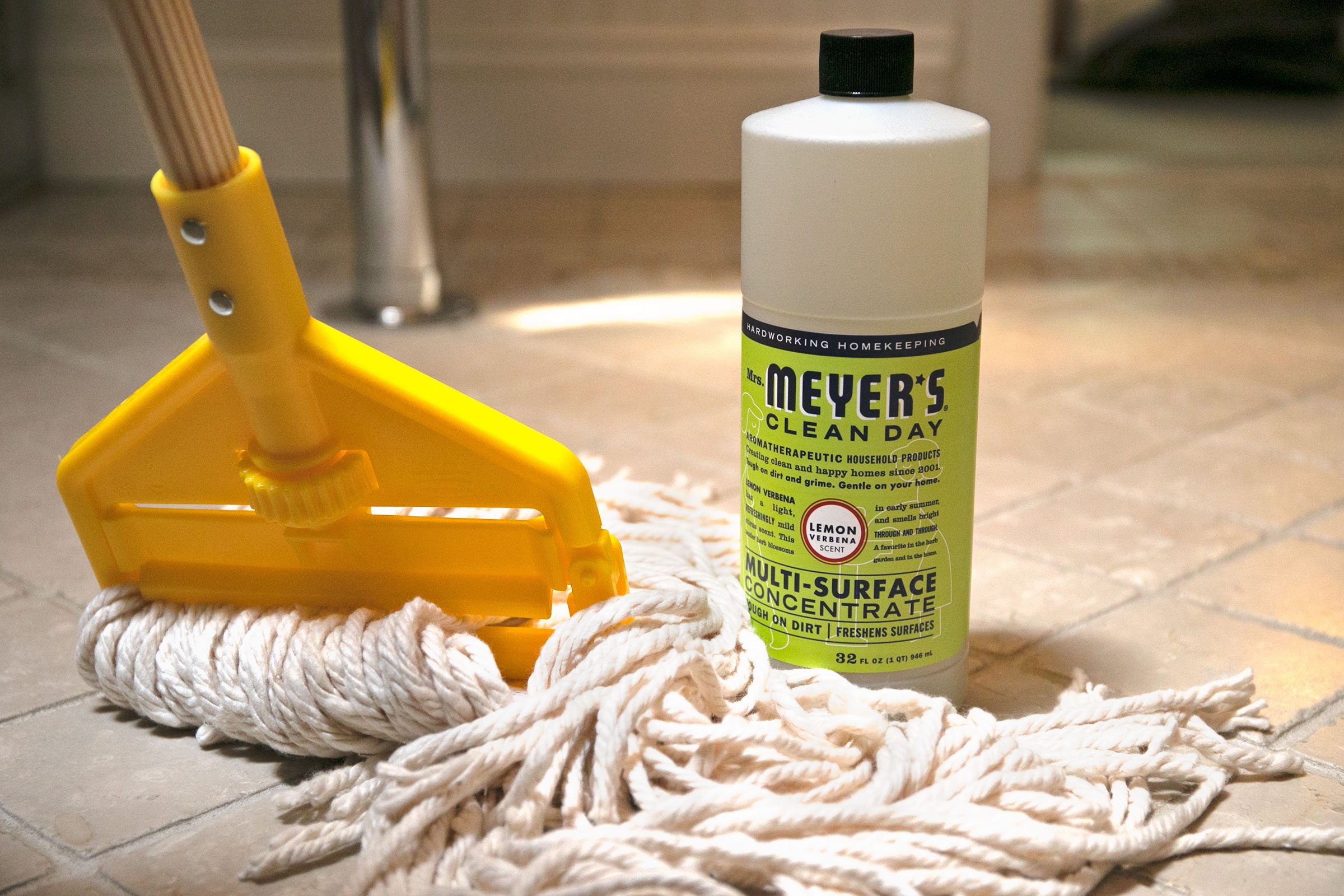 cleaning product and mop on tile bathroom floor