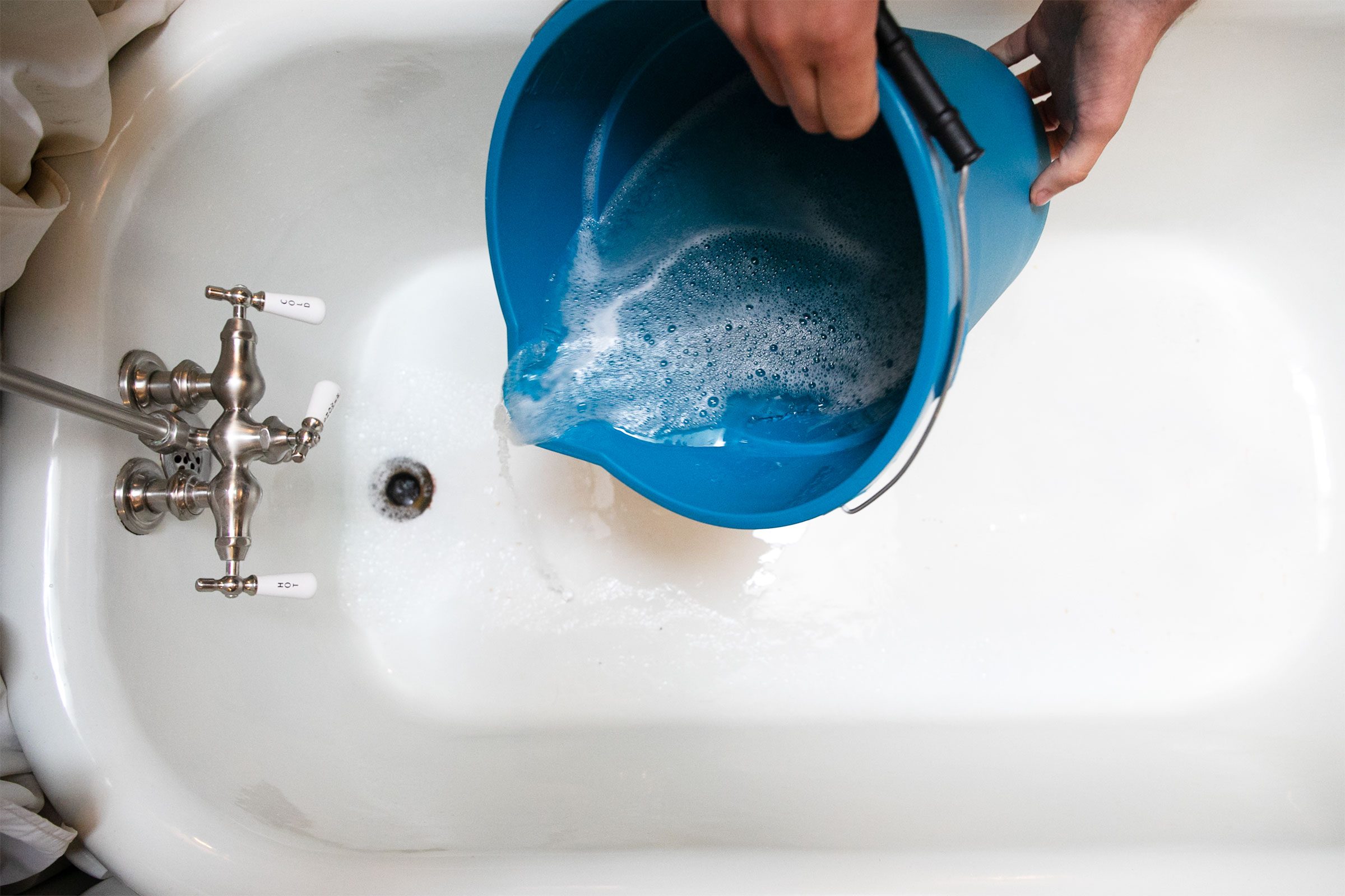 cleaning out mopping bucket in the bathtub 