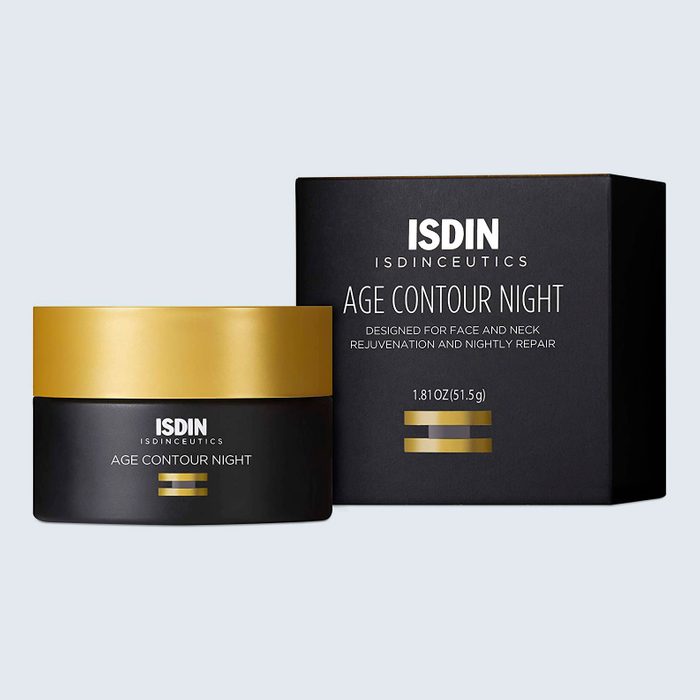 A black and gold skincare jar stands next to its matching box, labeled 