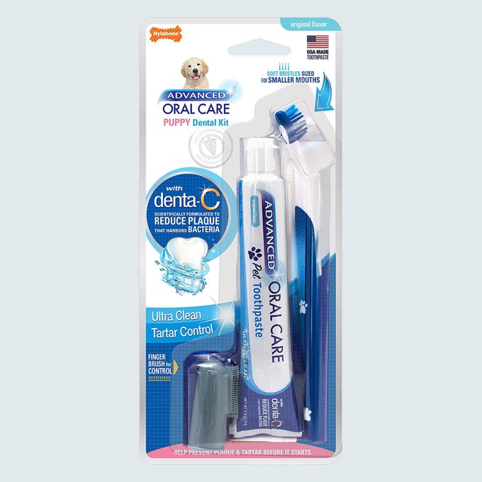 Puppy dental kit includes toothbrush, toothpaste, and finger brush in clear packaging, promoting tartar control with advanced oral care, and features a puppy image.