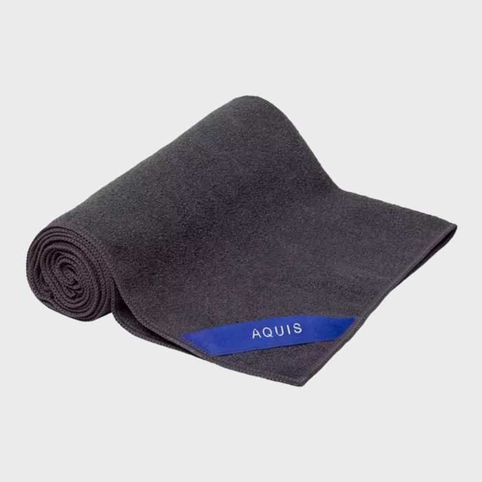 A rolled dark towel with a visible blue tag reading 