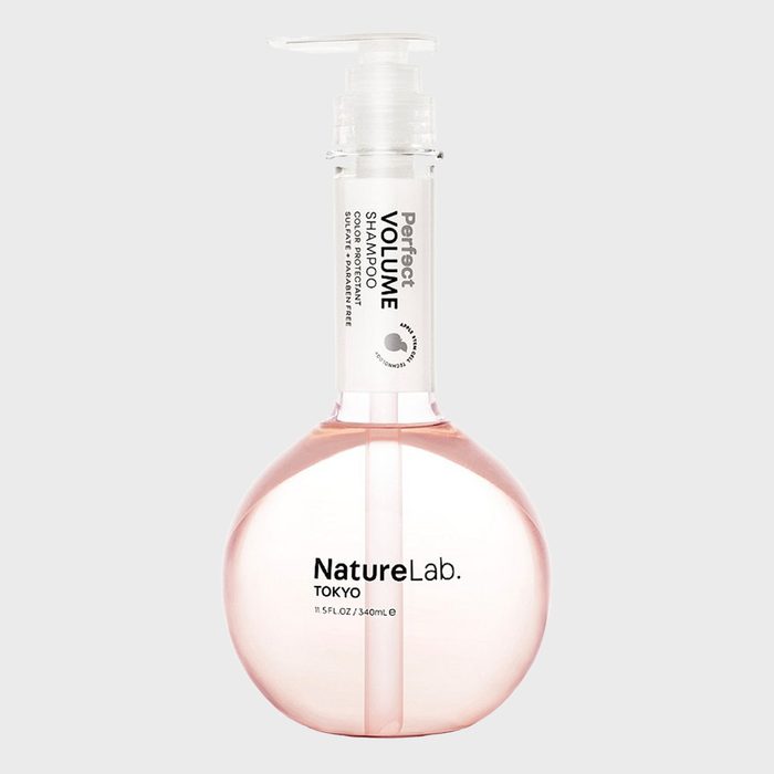 A round pink bottle with a pump dispenses shampoo labeled 