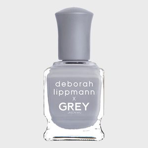 Nail polish bottle sits upright, filled with grey polish. Text on bottle: 