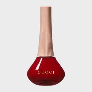 Red nail polish bottle with a tall, textured beige cap, and 