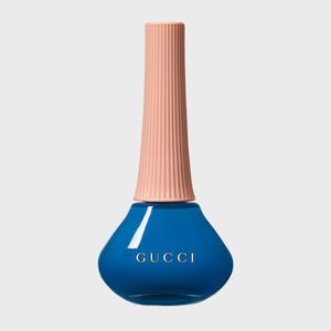 A blue nail polish bottle with a tall, ribbed pink cap, displays 