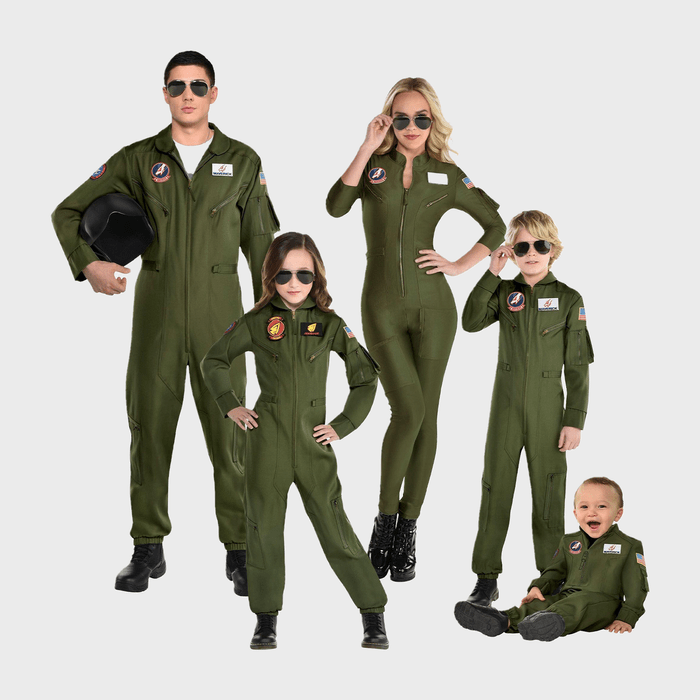 Individuals in aviator sunglasses wear matching green flight suits with patches, standing confidently in a studio setting with a neutral background.