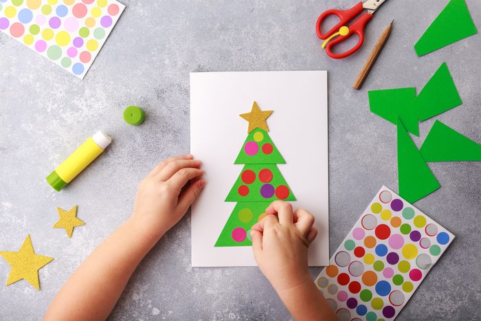 The child makes a greeting card Christmas paper collage