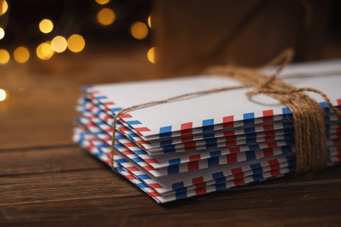 christmas card envelopes wrapped in burlap string next to christmas tree