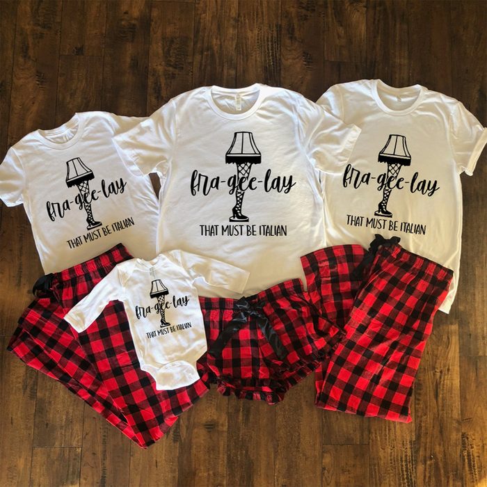 Four white shirts display a lamp illustration with â€œfra-gee-lay, that must be Italianâ€ text, paired with red plaid pajama bottoms on a wooden floor.