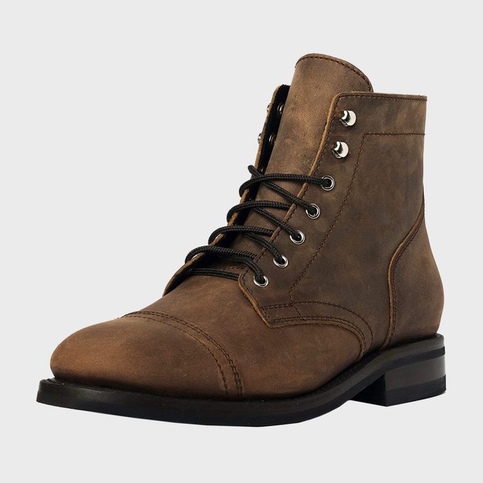 Brown leather boot sits against a plain white background, featuring black laces through metal eyelets, with visible stitching detailing.