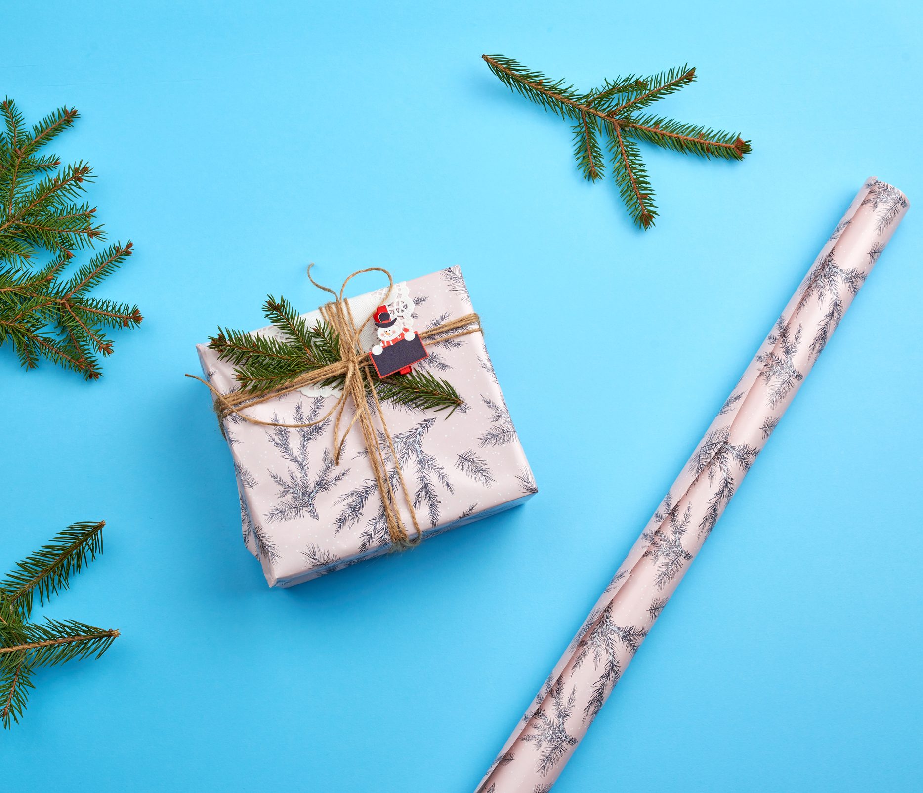 Gift Wrapped In Pink Paper And Tied With A Brown Rope, Decor From A Green Spruce Branch