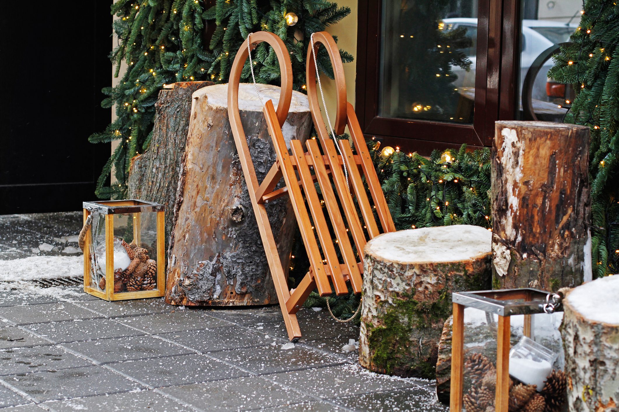 Wooden sled with stumps and glass candlesticks outdoor christmas decor