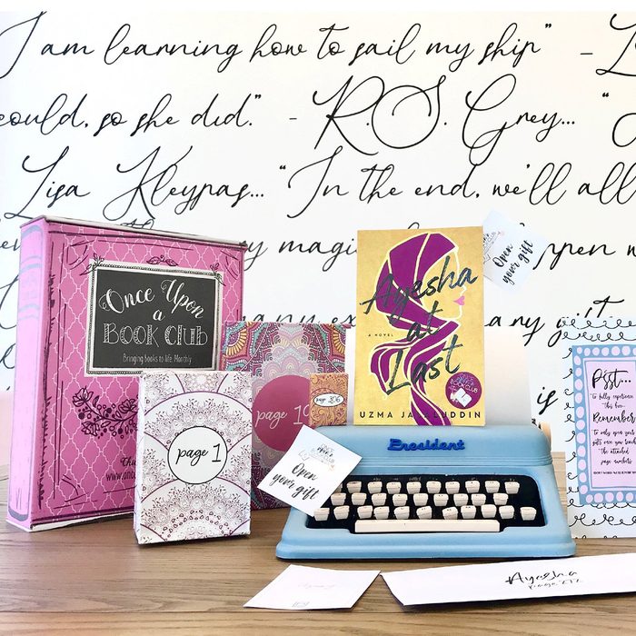 Typewriter holds book gifts on desk amidst literary quotes background.
