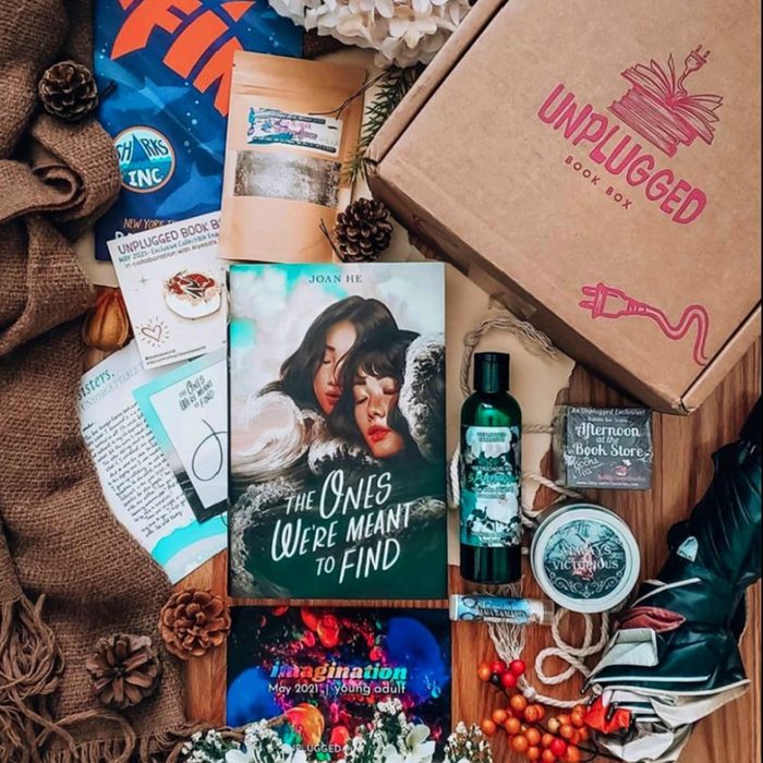 Book lies surrounded by themed items, including a box labeled 