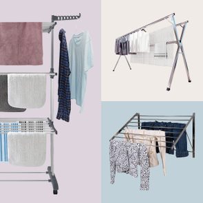Clothes racks hold various garments; one with towels and shirts, another with shirts and linens, and a third with shirts and jeans.