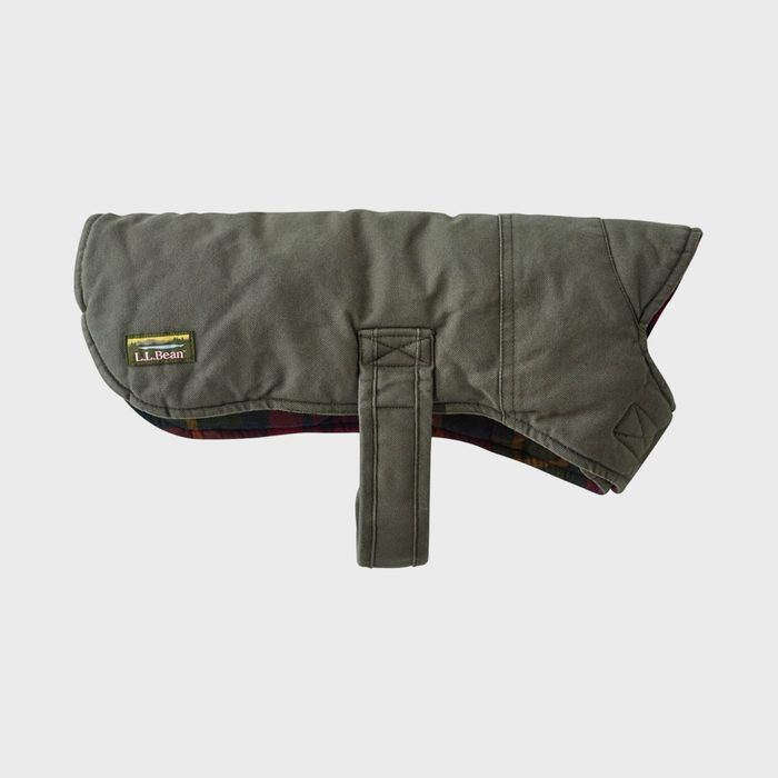 Green dog jacket lying flat, showing quilted texture and plaid lining. Features 