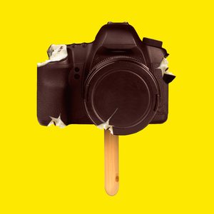 A camera shaped like an ice cream bar with several bites taken out of it, set against a bright yellow background.