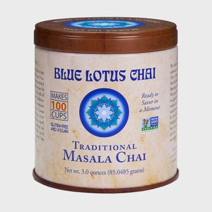 A circular tin holds Blue Lotus Chai, offering gluten-free and vegan masala blend for 100 cups. It's labeled non-GMO, ready to enjoy quickly.