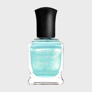 Turquoise nail polish bottle stands upright, displaying 