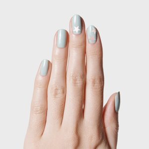 Hand displays pale blue nails with white star designs, set against a plain white background.