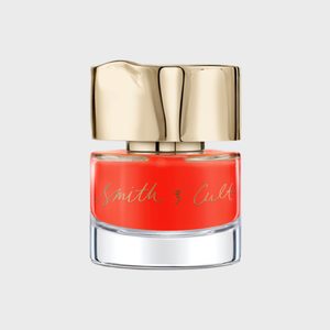 Nail polish bottle, standing upright, features vibrant red color with a gold, irregular-shaped cap; labeled 
