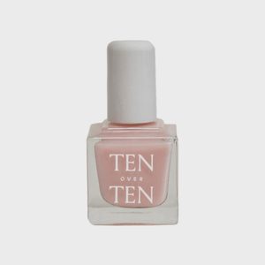 A pale pink nail polish bottle stands upright, labeled 