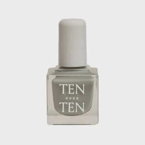Bottle stands upright containing gray nail polish labeled 