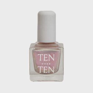 Nail polish bottle stands upright, featuring a pink shade with white text 
