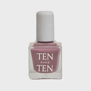 A square glass bottle holds pink nail polish labeled 