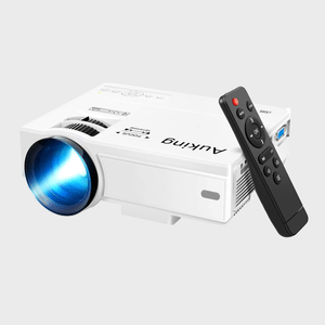 A white projector emits blue light; it's paired with a black remote control. Both are placed against a plain gray background.