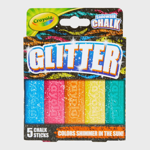 Five glittery sidewalk chalk sticks displayed in packaging, featuring vibrant colors and a bold â€œGLITTERâ€ label. The text reads â€œColors shimmer in the sun!â€