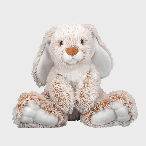 A fluffy stuffed bunny sits on a plain surface, ears drooping, with a light gray background.
