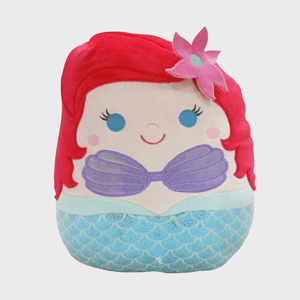 A plush toy depicts a cartoon mermaid with red hair and purple top; resting on a simple white background.