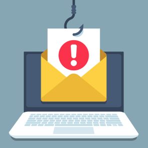 A yellow envelope, containing a paper with a red exclamation mark, hangs from a fish hook in front of a laptop screen.