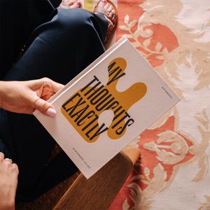 A hand holds a notebook titled 
