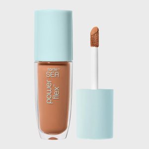 Concealer bottle stands with opened cap revealing applicator; light blue cap, labeled 