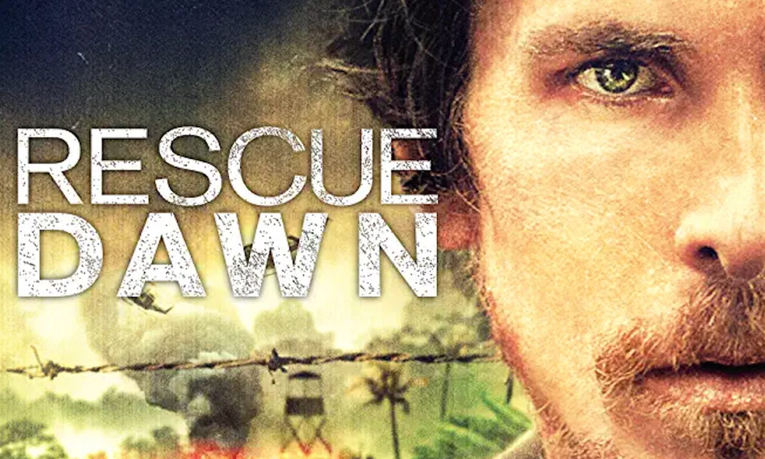 A man's intense face partially shown; background with explosions, barbed wire. Text reads: "RESCUE DAWN."