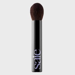 Makeup brush stands upright; black handle with 
