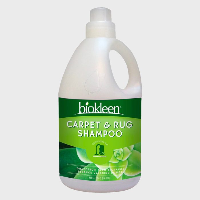 A bottle of Biokleen Carpet & Rug Shampoo sits against a plain background, labeled with green graphics indicating grapefruit and orange essence cleaning power.