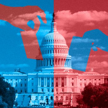 Hands place ballots against a divided red and blue U.S. Capitol, symbolizing political division. Cloudy sky above and trees on the sides.